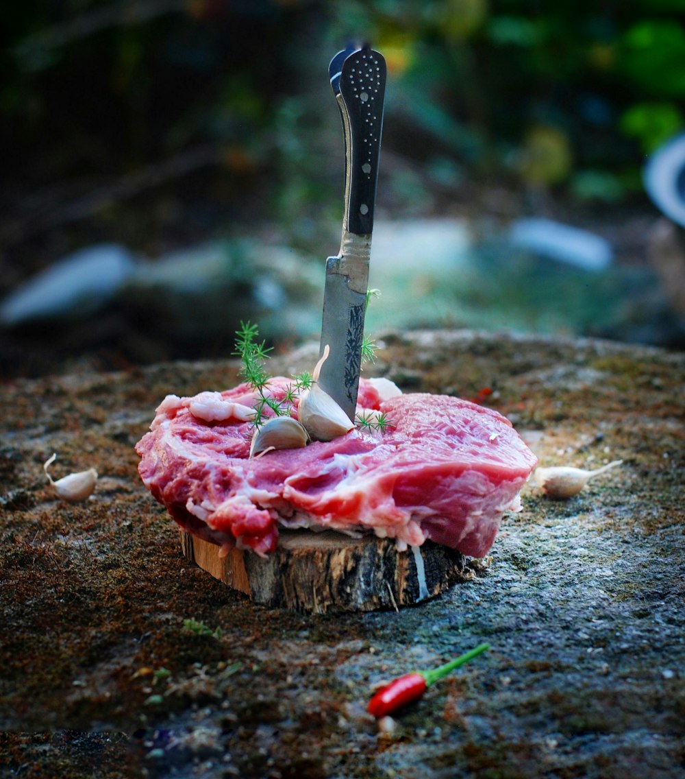 carne en rodajas en tabla de cortar de madera marrón