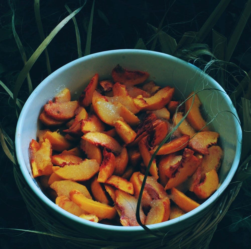 sliced orange fruits in blue ceramic bowl