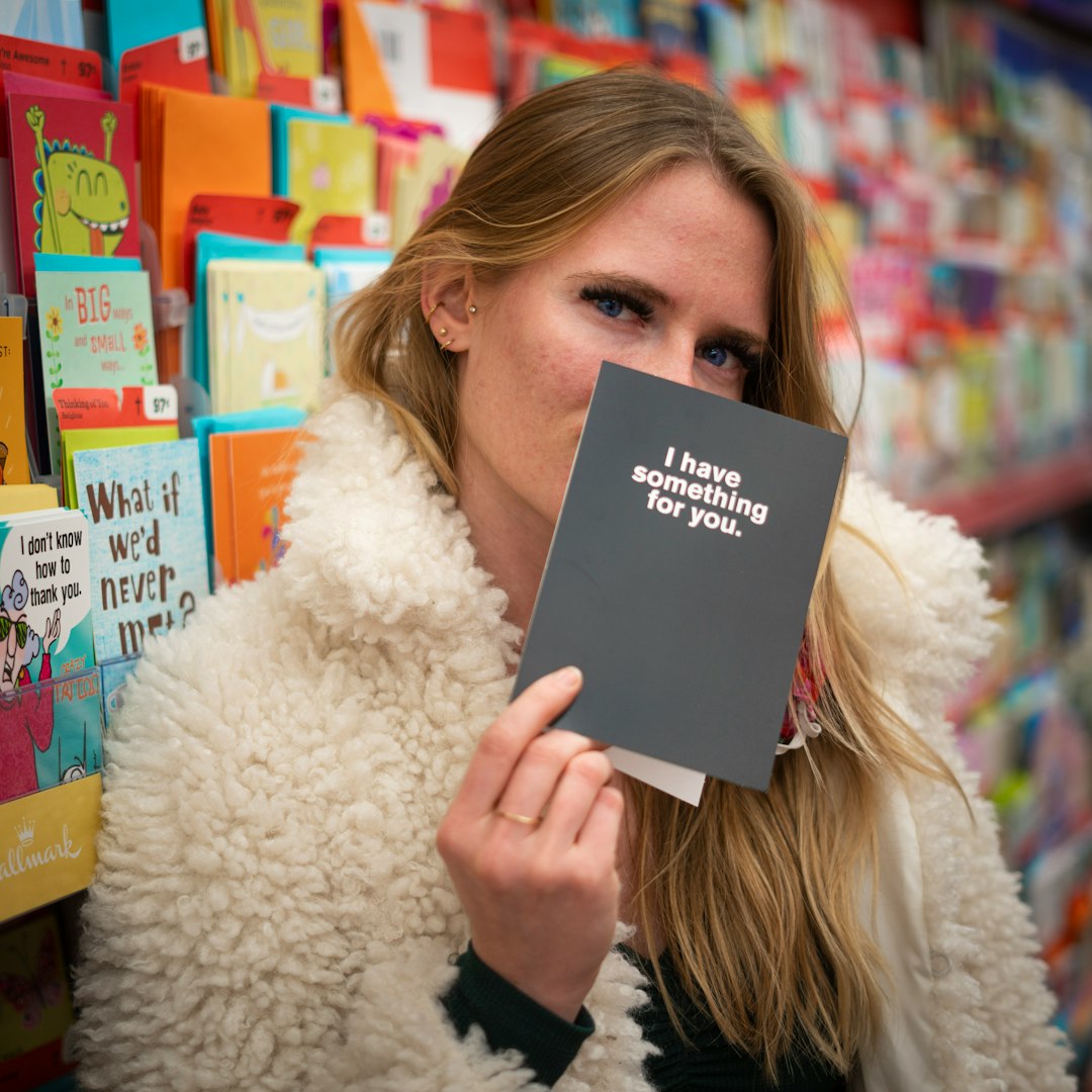 woman in white fur coat holding book