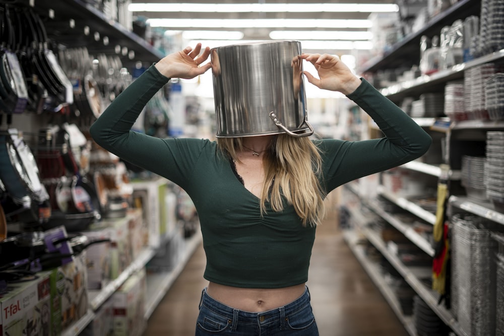 woman in blue long sleeve shirt holding stainless steel mug