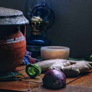 A rustic kitchen scene with traditional South Indian cookware and fresh spices laid out.