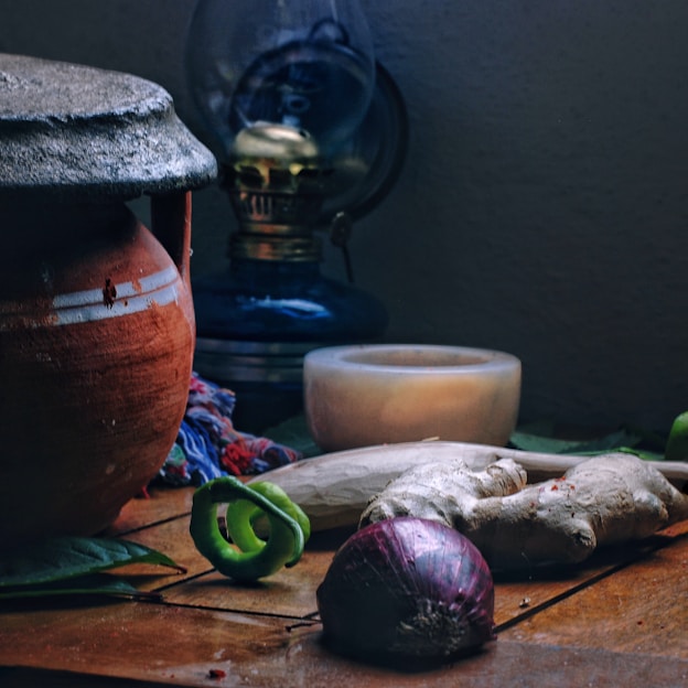 A rustic kitchen scene featuring clay pots filled with fresh vegetables and herbs.
