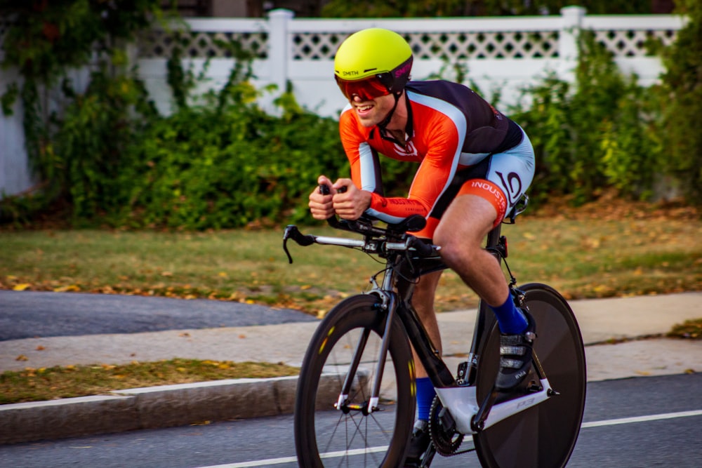 man in red and black shirt riding on black bicycle during daytime