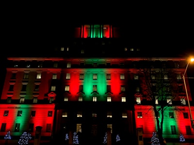 A large office building wrapped in colorful synchronized Christmas lights glowing against the night sky.