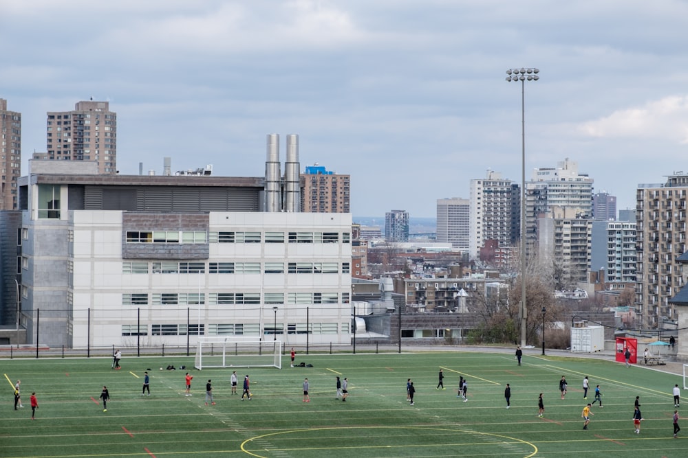 green grass field near white concrete building during daytime