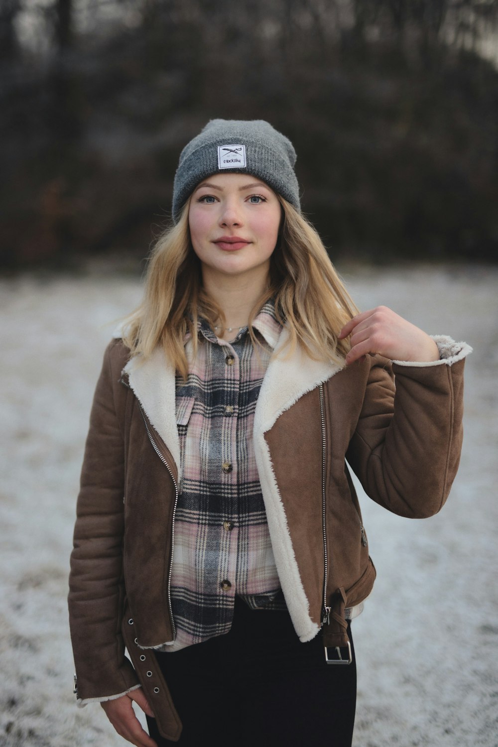 donna in cappotto marrone e berretto in maglia grigio