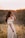 woman in white dress standing on brown grass field during daytime