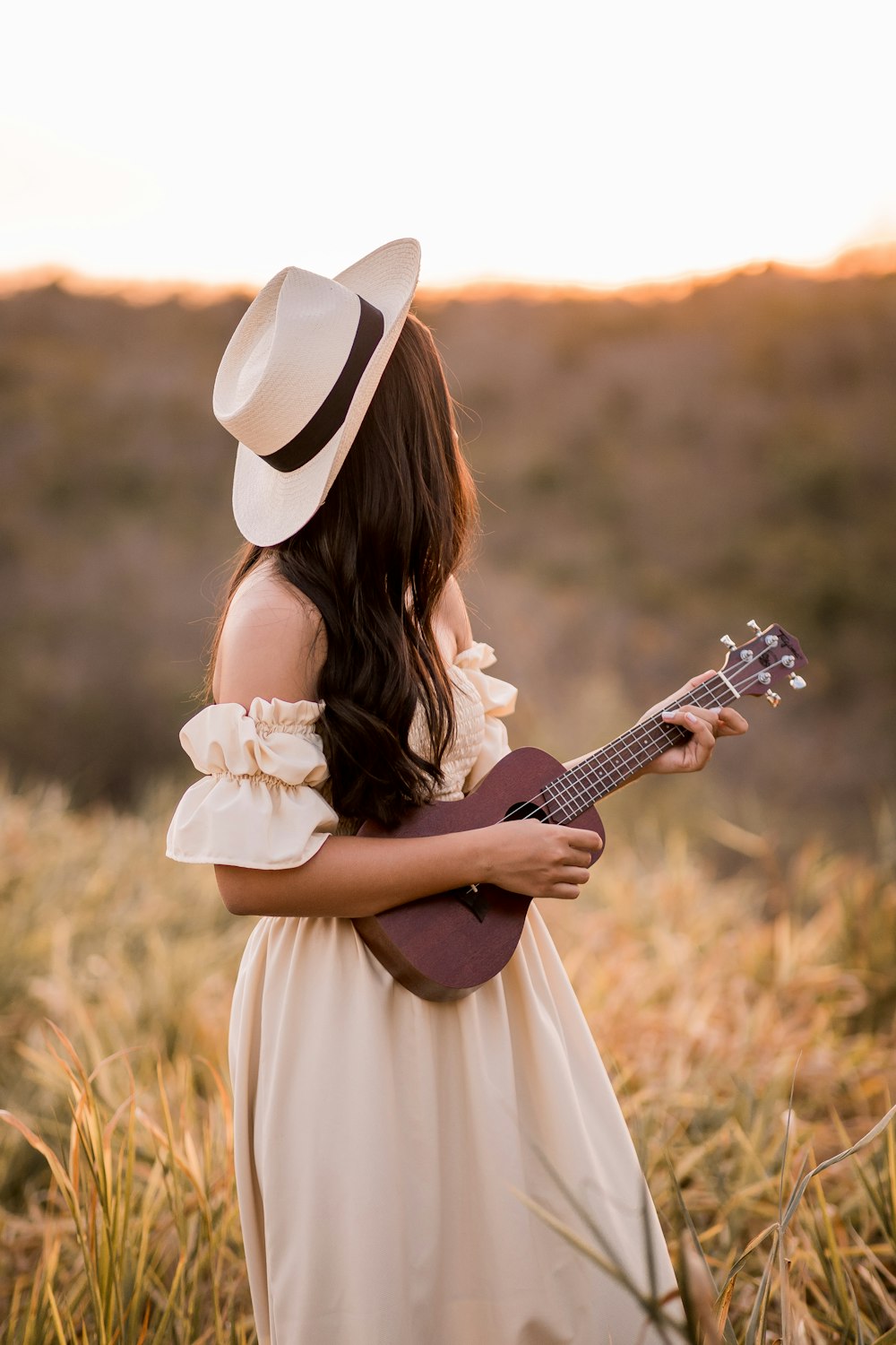 Frau im weißen Kleid spielt akustische Gitarre