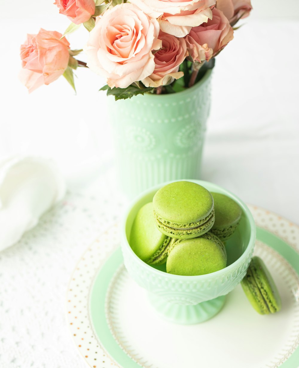 green egg on white ceramic bowl beside pink flowers