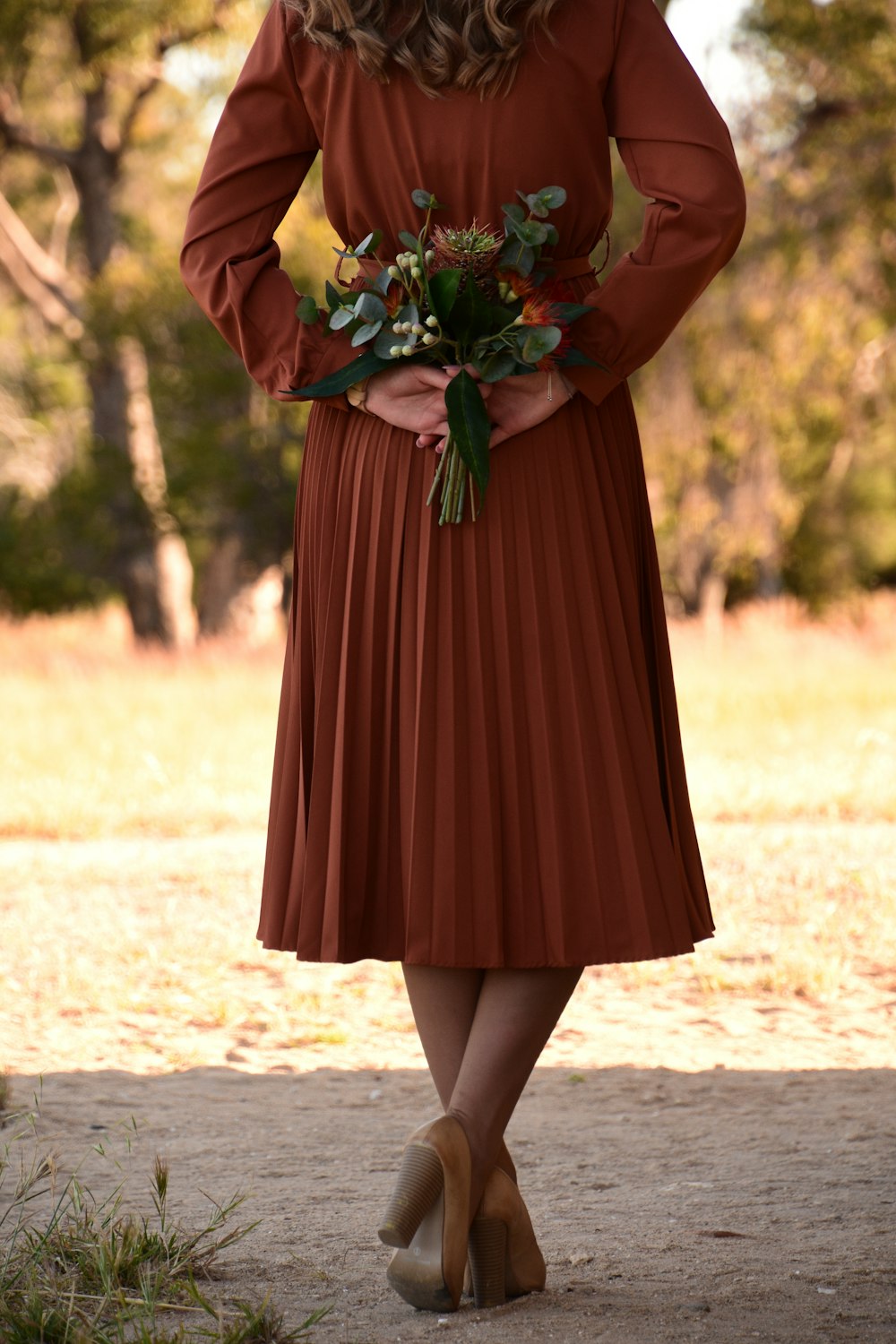 woman in red dress holding bouquet of flowers