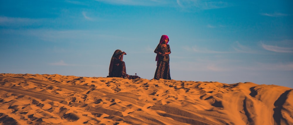 2 women standing on desert during daytime
