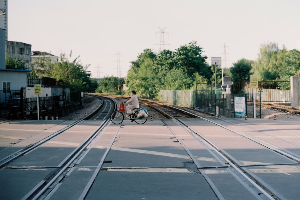 man in black jacket riding on bicycle on road during daytime