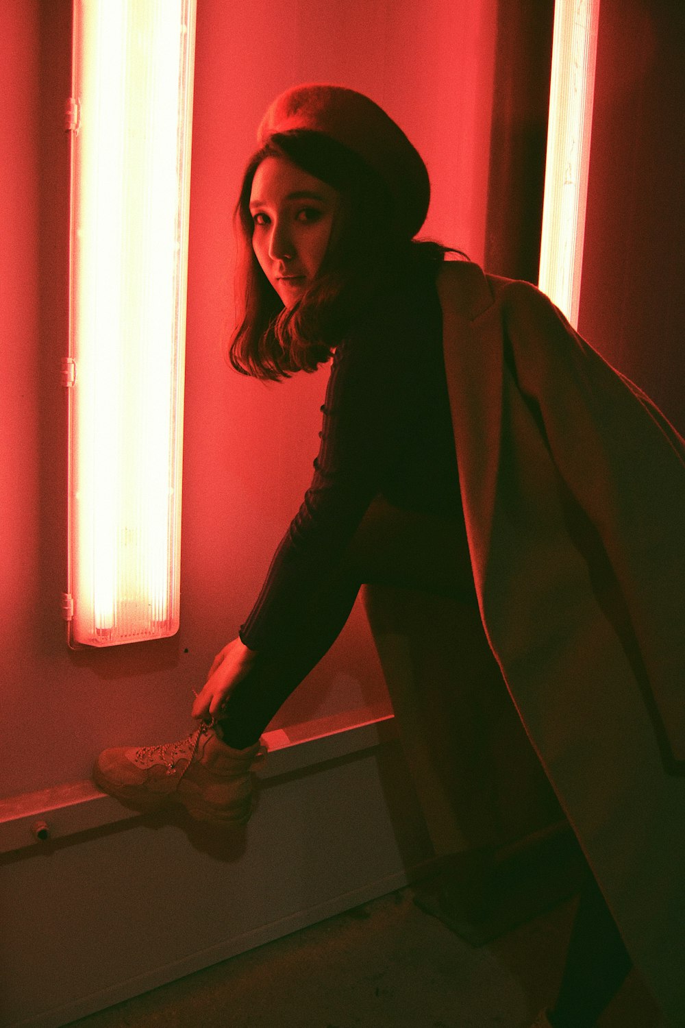 woman in black jacket and black pants standing beside window