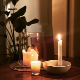 a table topped with two candles and a bowl