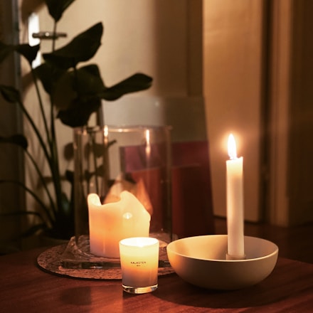 a table topped with two candles and a bowl