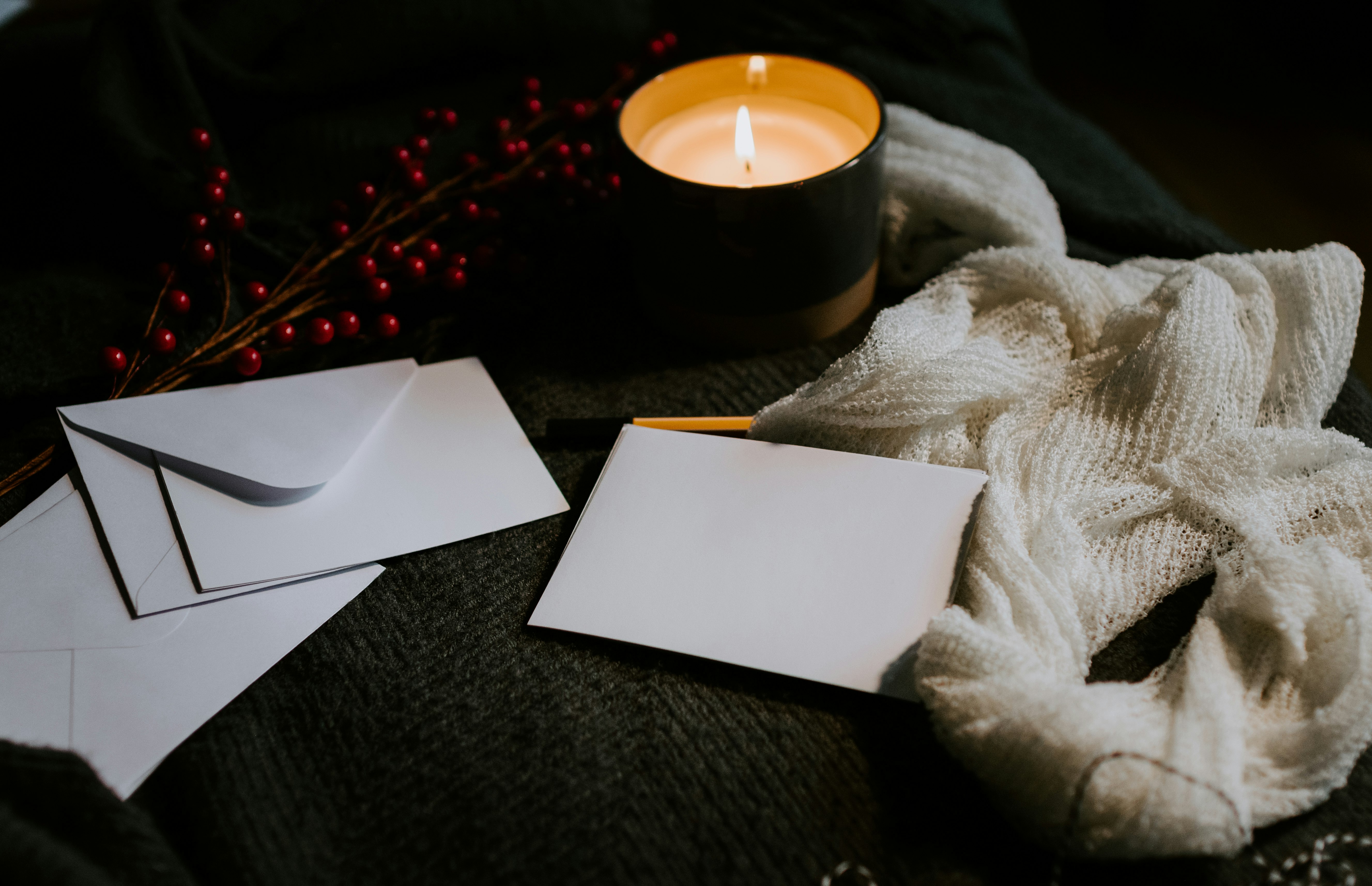 Blank cards on a table with envelopes and a candle