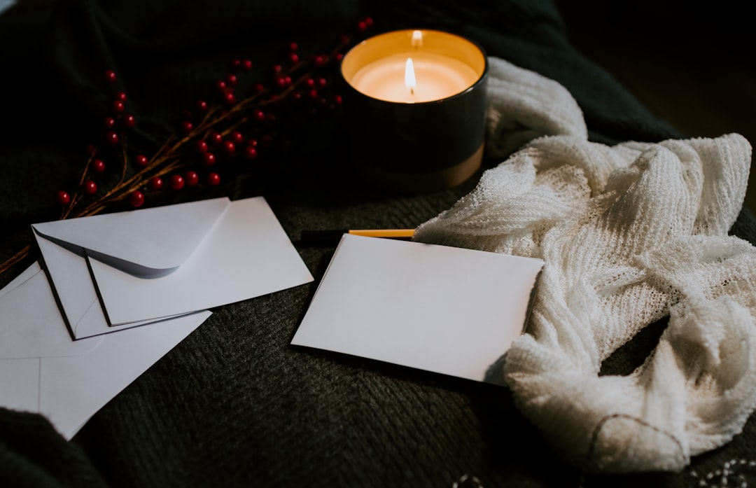 white paper on white textile, Blank cards on a table with envelopes and a candle