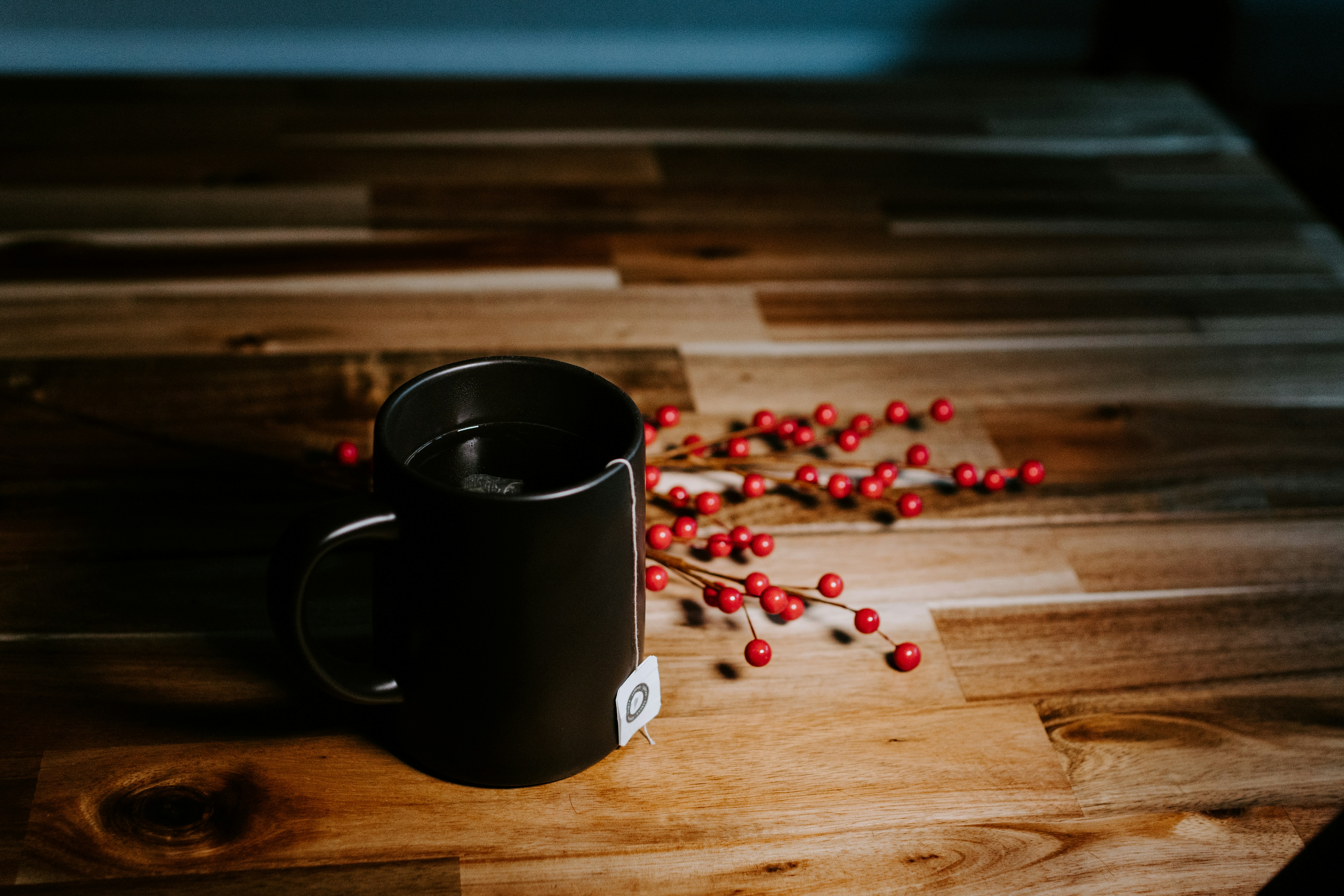 Tea mug on a wooden table with berries