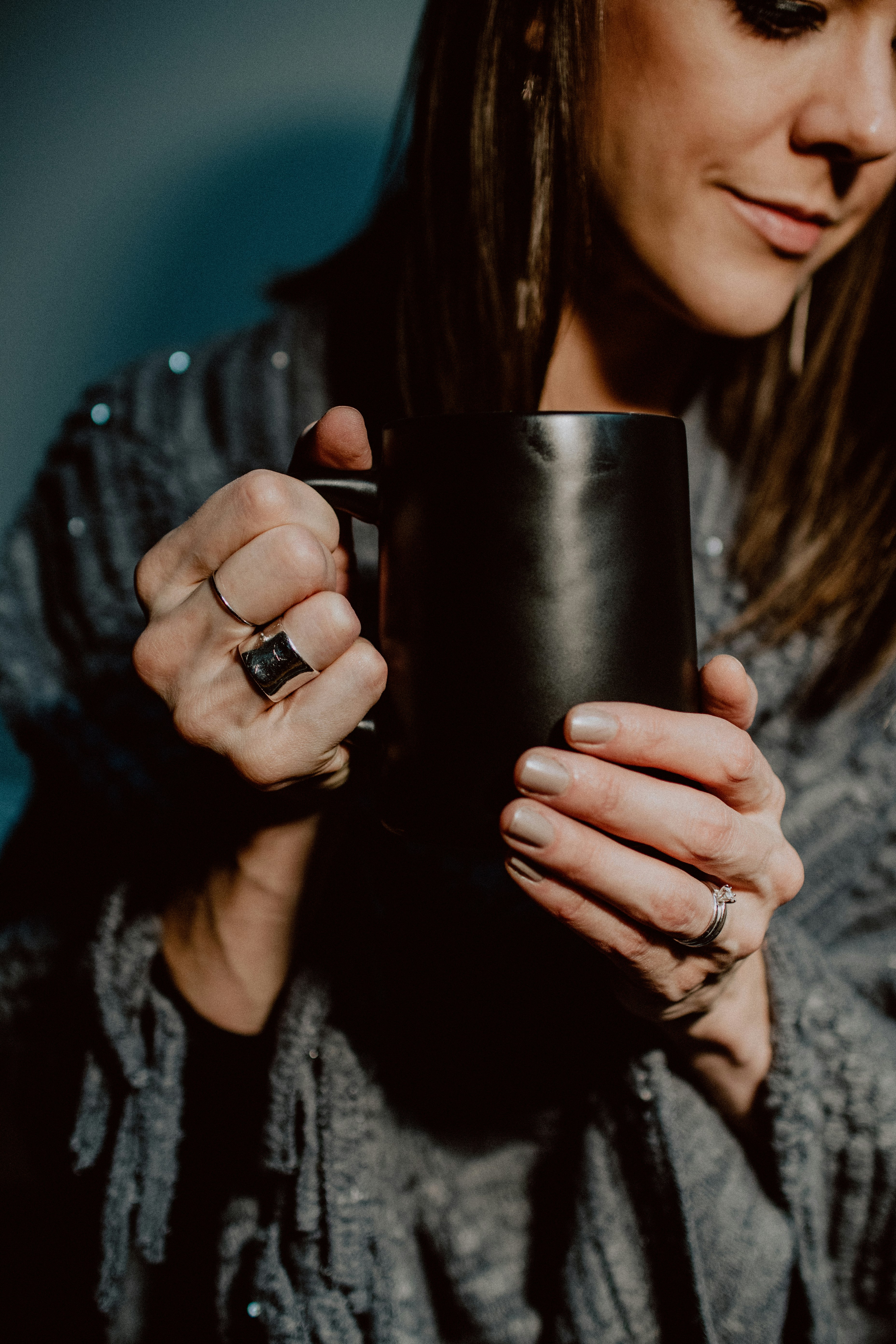 woman in black long sleeve shirt holding black ceramic mug