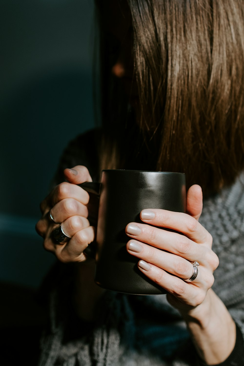 woman holding black ceramic mug