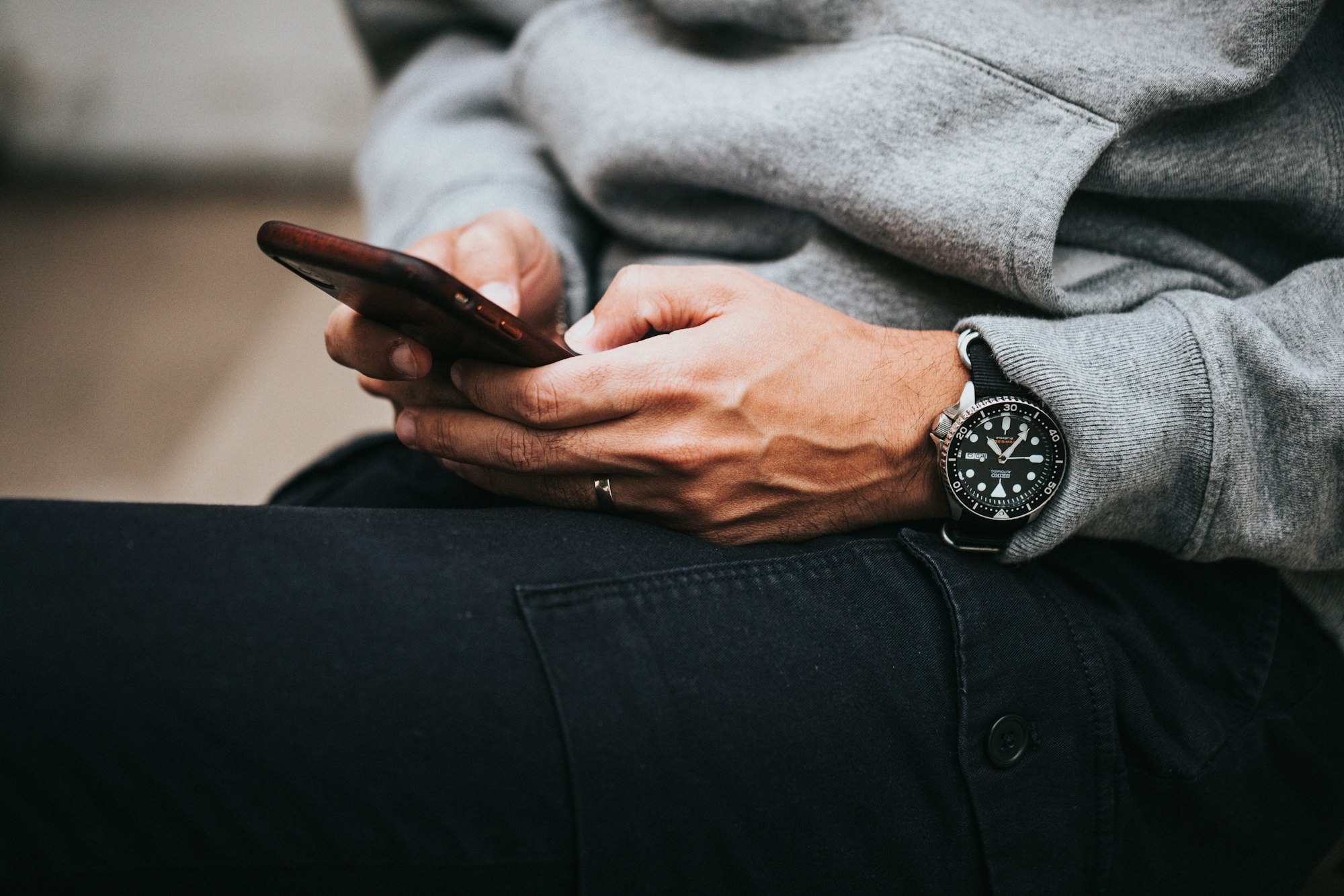 person in gray sweater wearing black and silver chronograph watch