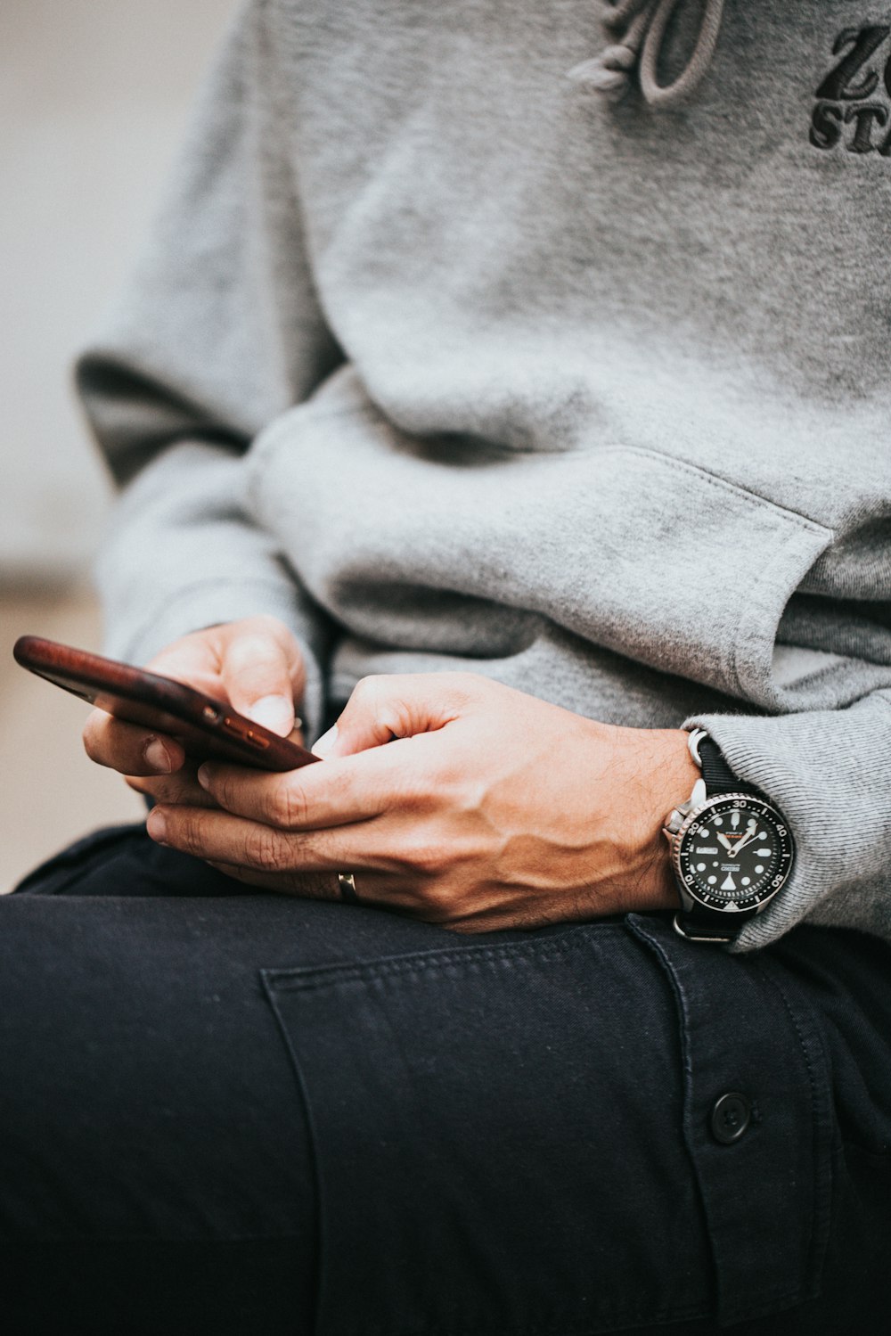 person in gray sweater wearing black and silver chronograph watch