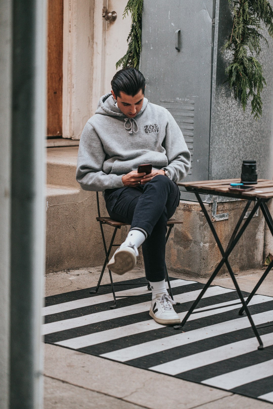 man in gray sweater sitting on brown wooden folding table