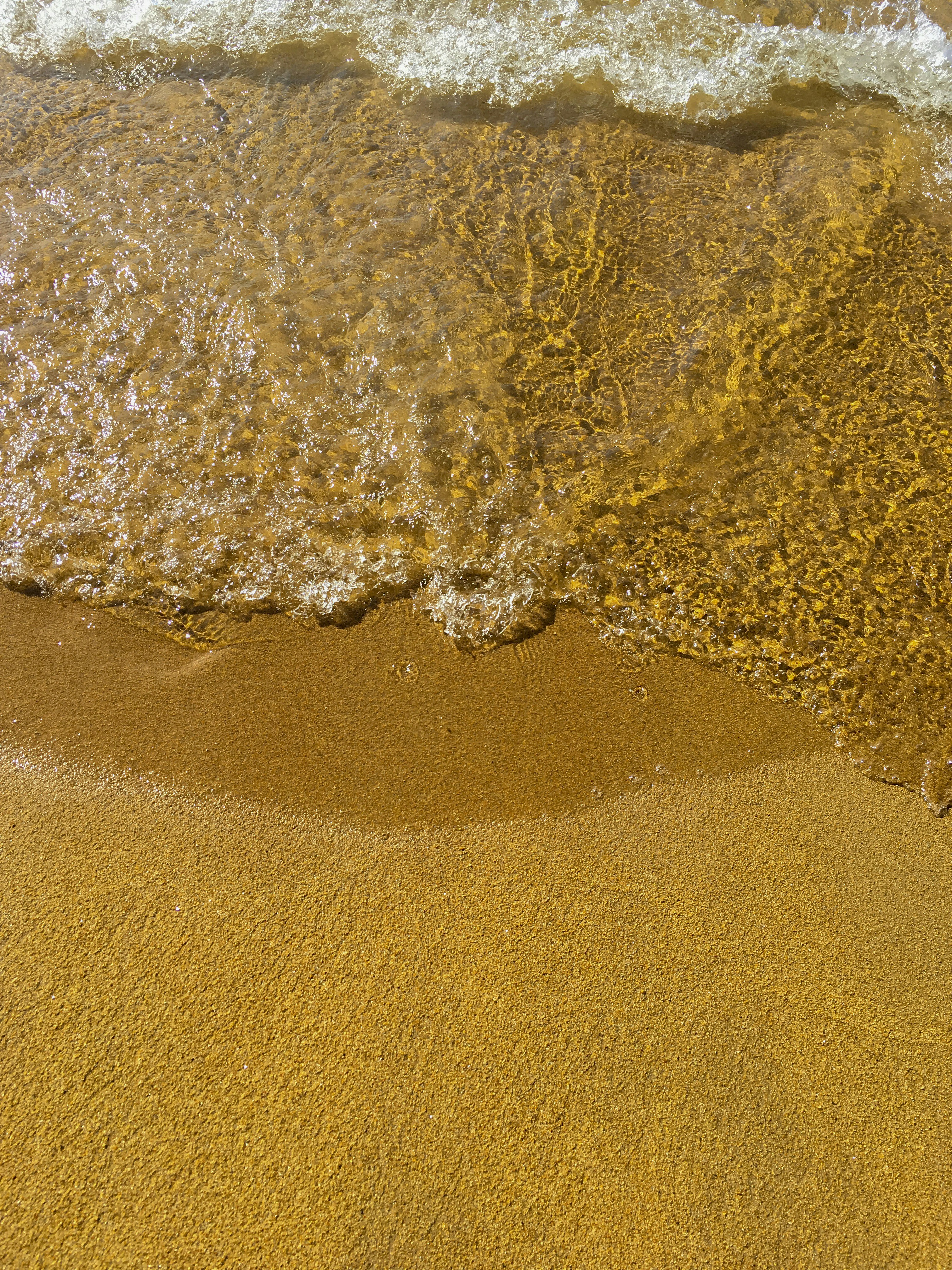 brown sand and body of water