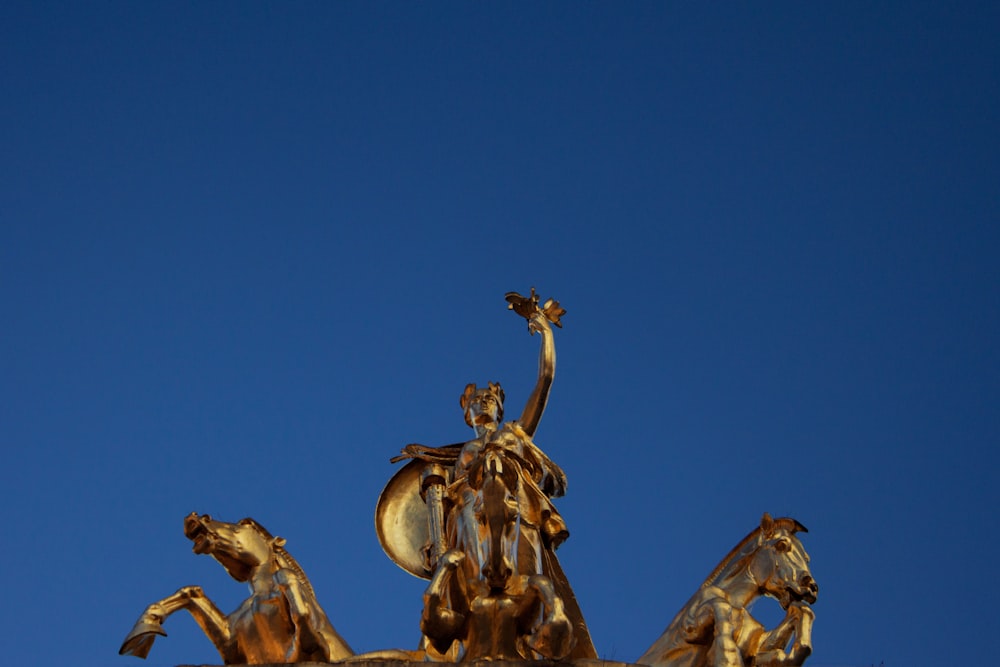 statue d’or sous le ciel bleu pendant la journée