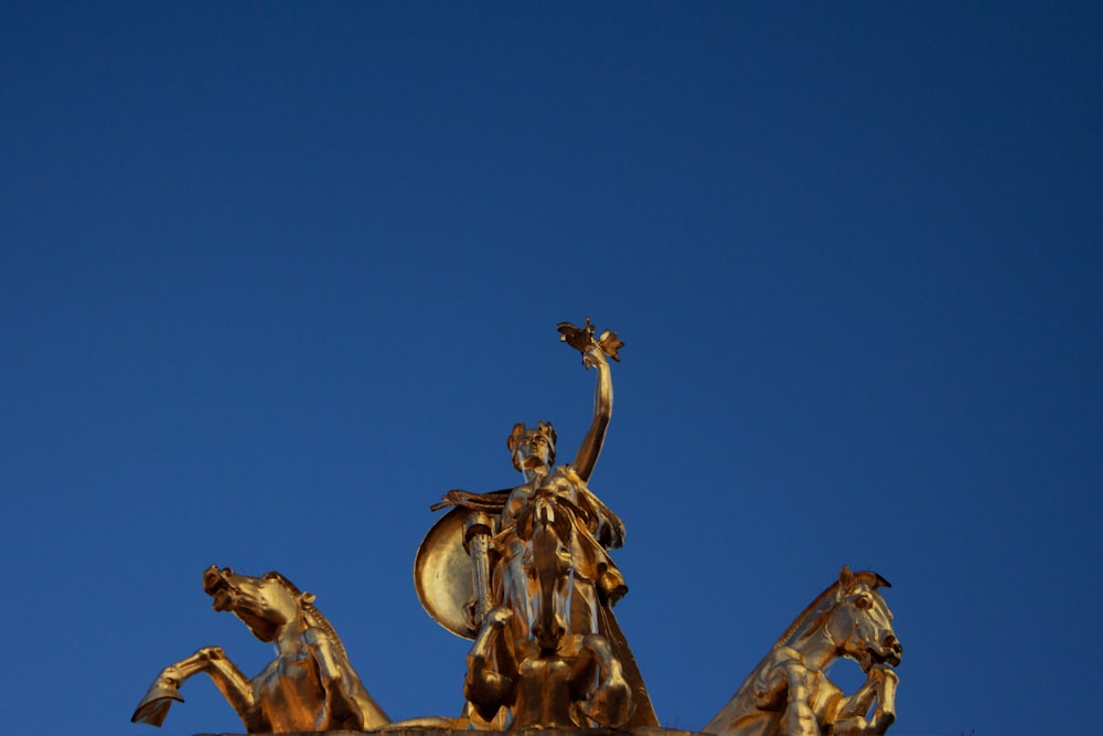 gold statue under blue sky during daytime