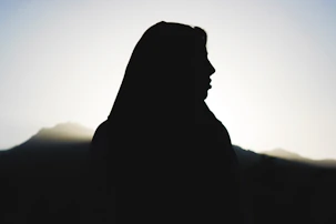 silhouette of mans head statue during sunset