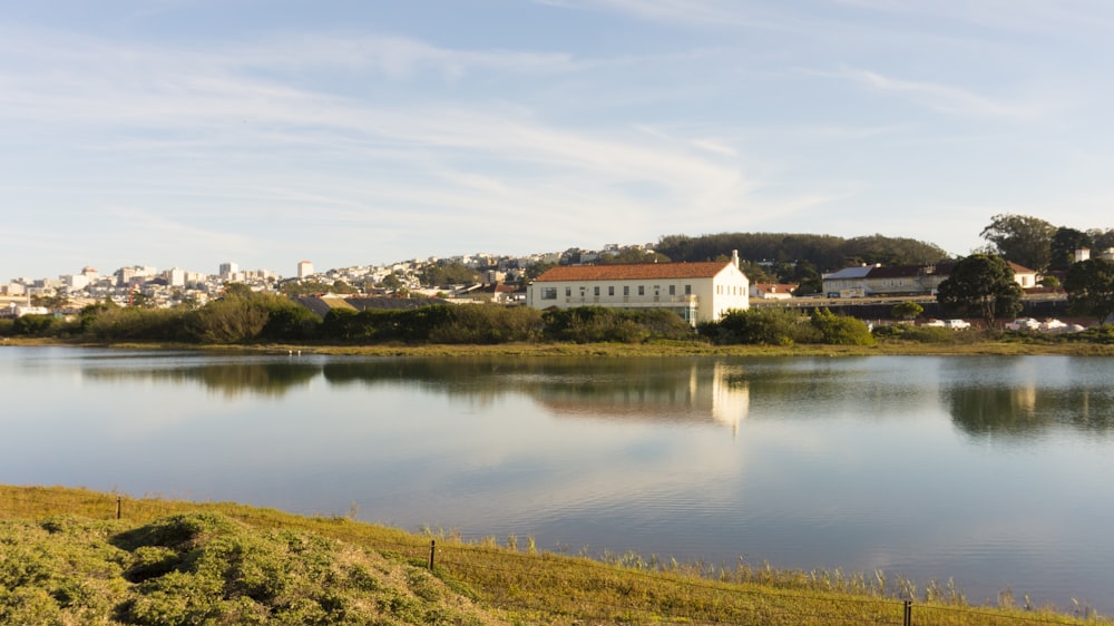 white and brown house near lake under blue sky during daytime