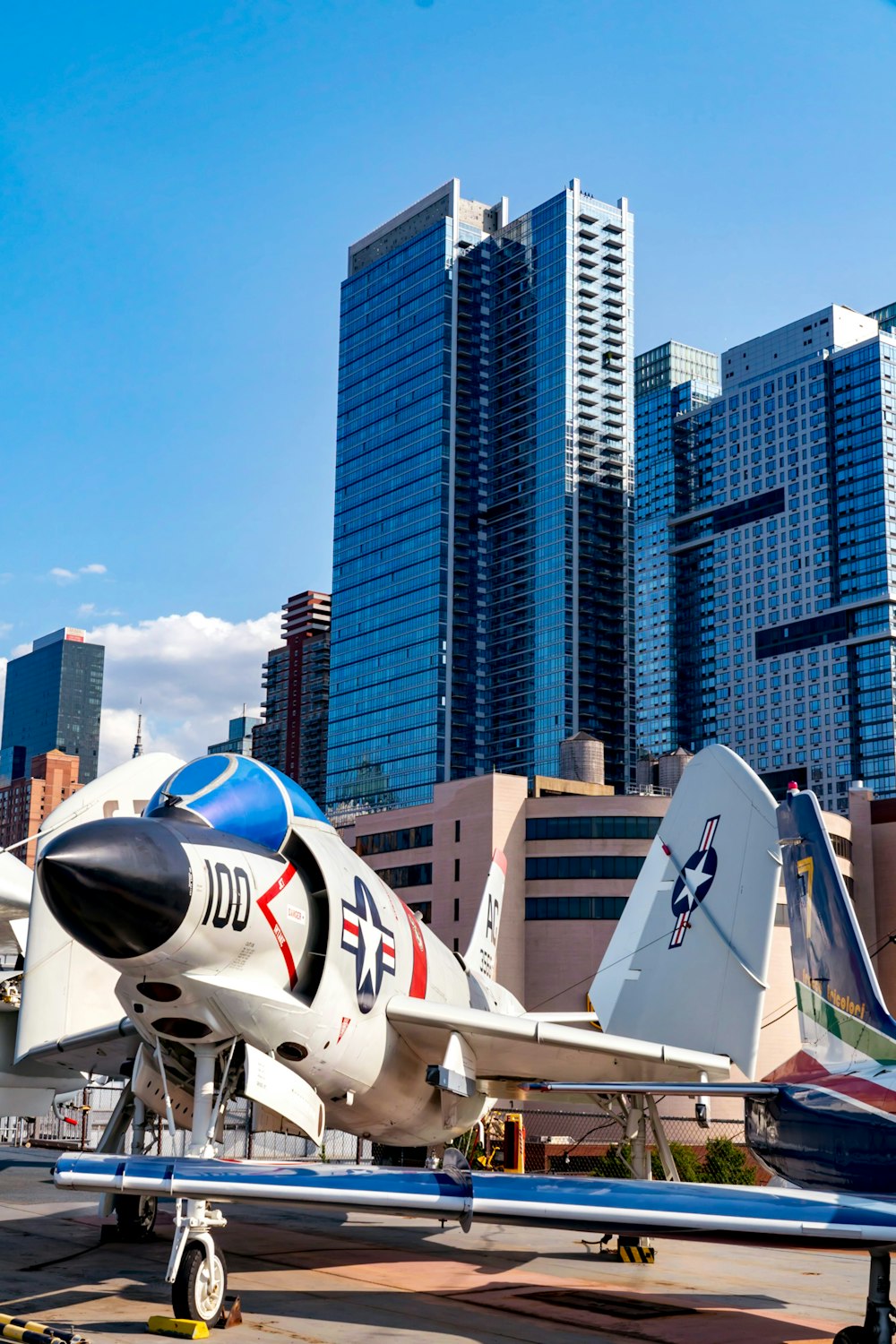 white and red airplane flying over city buildings during daytime