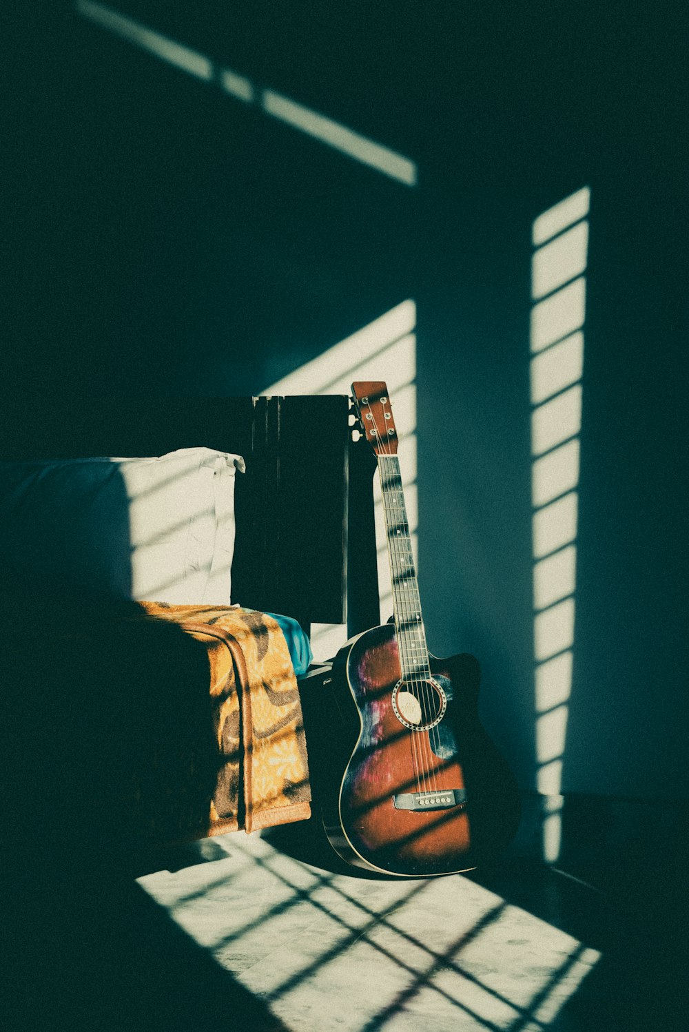 brown acoustic guitar on black and white striped textile