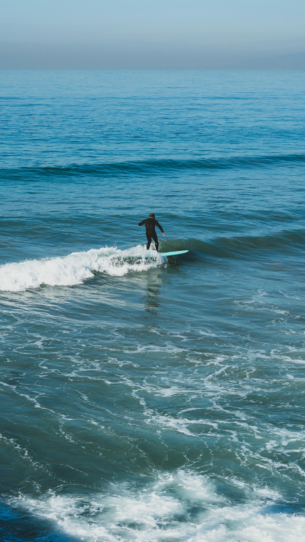 man surfing on sea waves during daytime