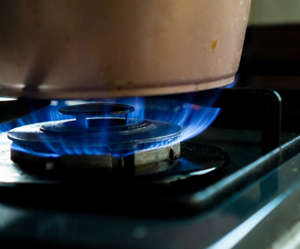 récipient en plastique blanc sur cuisinière à gaz noire