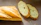 Close-up of a crispy baguette resting on a wooden table with soft natural light.