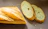 Close-up of a crispy baguette resting on a wooden table with soft natural light.