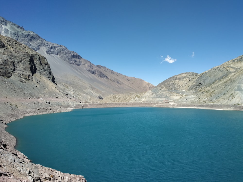 blue sea beside mountain under blue sky during daytime