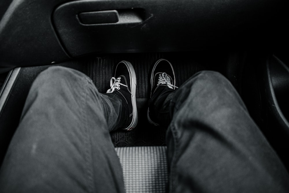 person in black pants and black and white sneakers