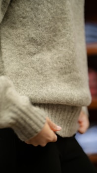 Close-up of a finely woven cashmere sweater in deep charcoal gray, highlighting fabric texture.