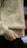 A close-up of a person wearing a light gray woolen sweater, with hands adjusting the bottom hem. The focus is on the texture of the sweater and the neutral colors.
