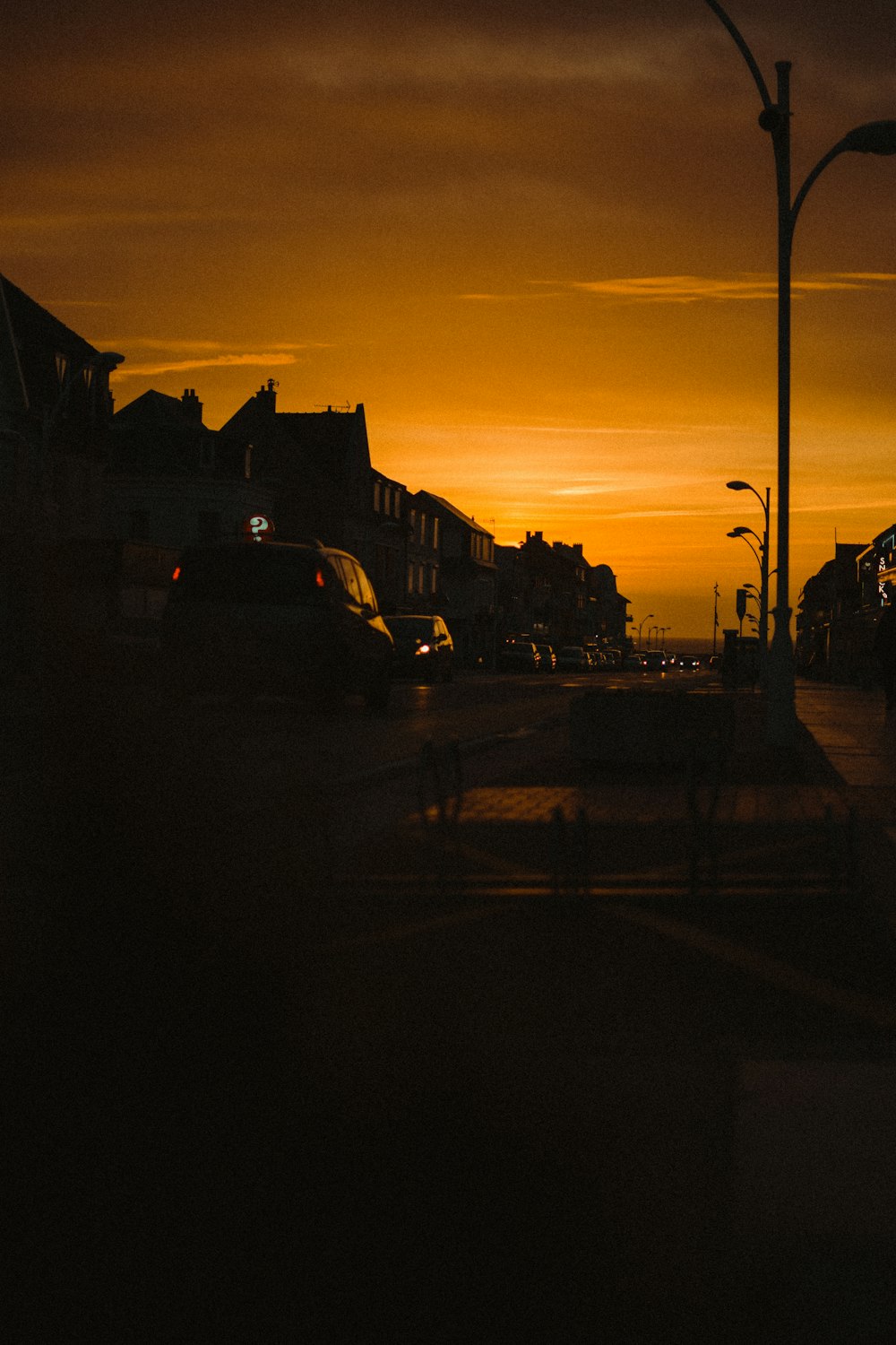 Coches aparcados a un lado de la carretera durante la puesta de sol