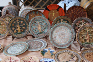 Artistic ceramic decorative pieces with intricate patterns displayed on a rustic wooden table.