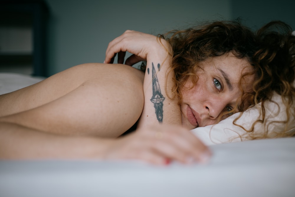 topless woman lying on bed