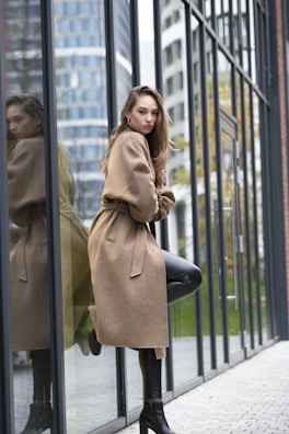 Editorial shot of a woman in a sleek beige co-ord set against a minimalist urban backdrop.