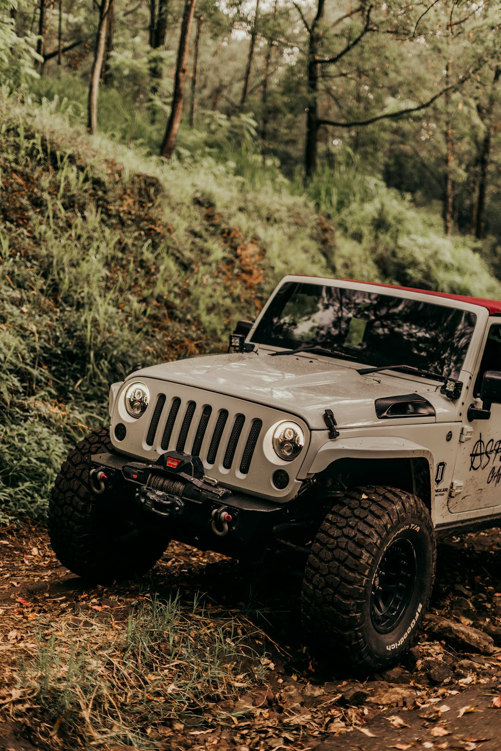 white and black jeep wrangler on dirt road during daytime