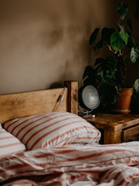 A bedroom scene showcasing a wooden bed frame with soft linens and bedside tables.
