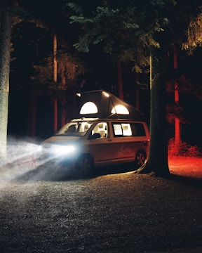 An inverter and charger setup inside a camper van with LED lights glowing warmly.