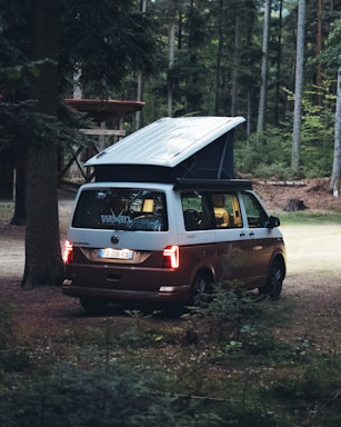 Cozy camper van parked in a scenic forest clearing at sunset